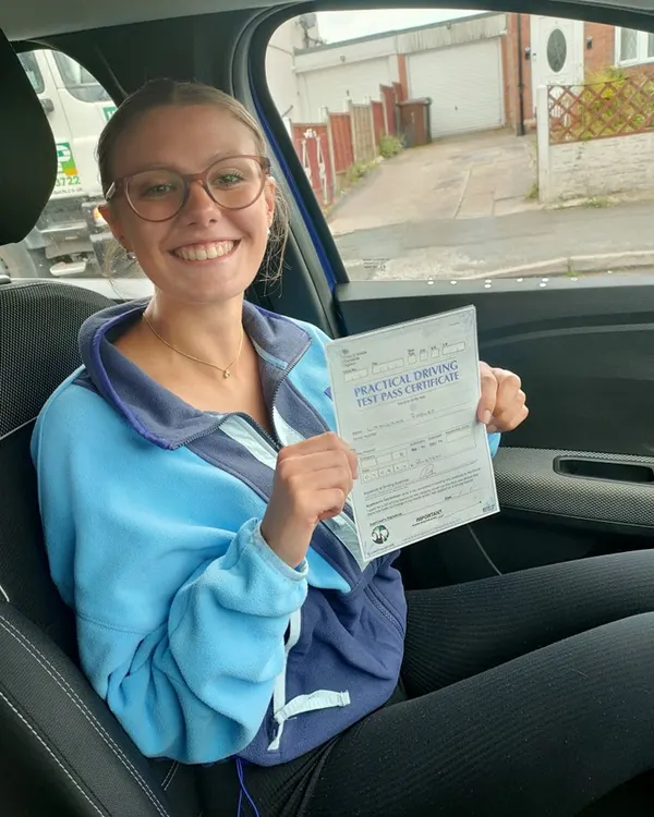 Learner driver celebrating passing their practical driving test